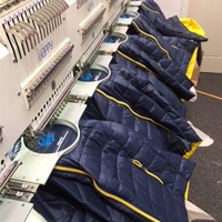 Padded jackets being embroidered with company logo