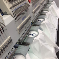 White t-shirts being embroidered with logo