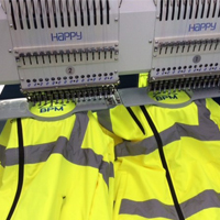 Workwear / PPE being embroidered with a company logo using a Happy embroidery machine