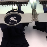 Black shirts with logo being embroidered to them